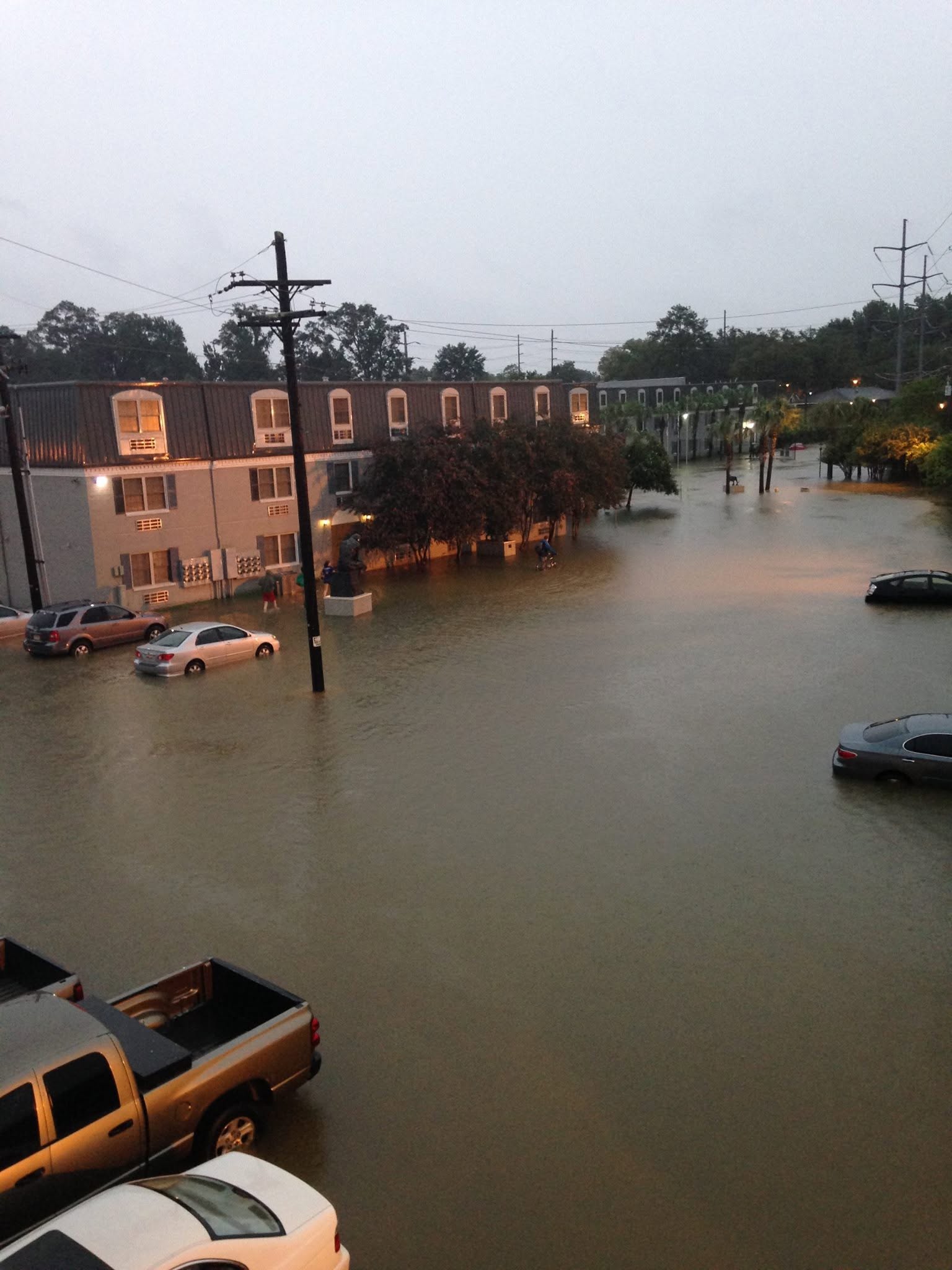 A flooded apartment complex parking lot.